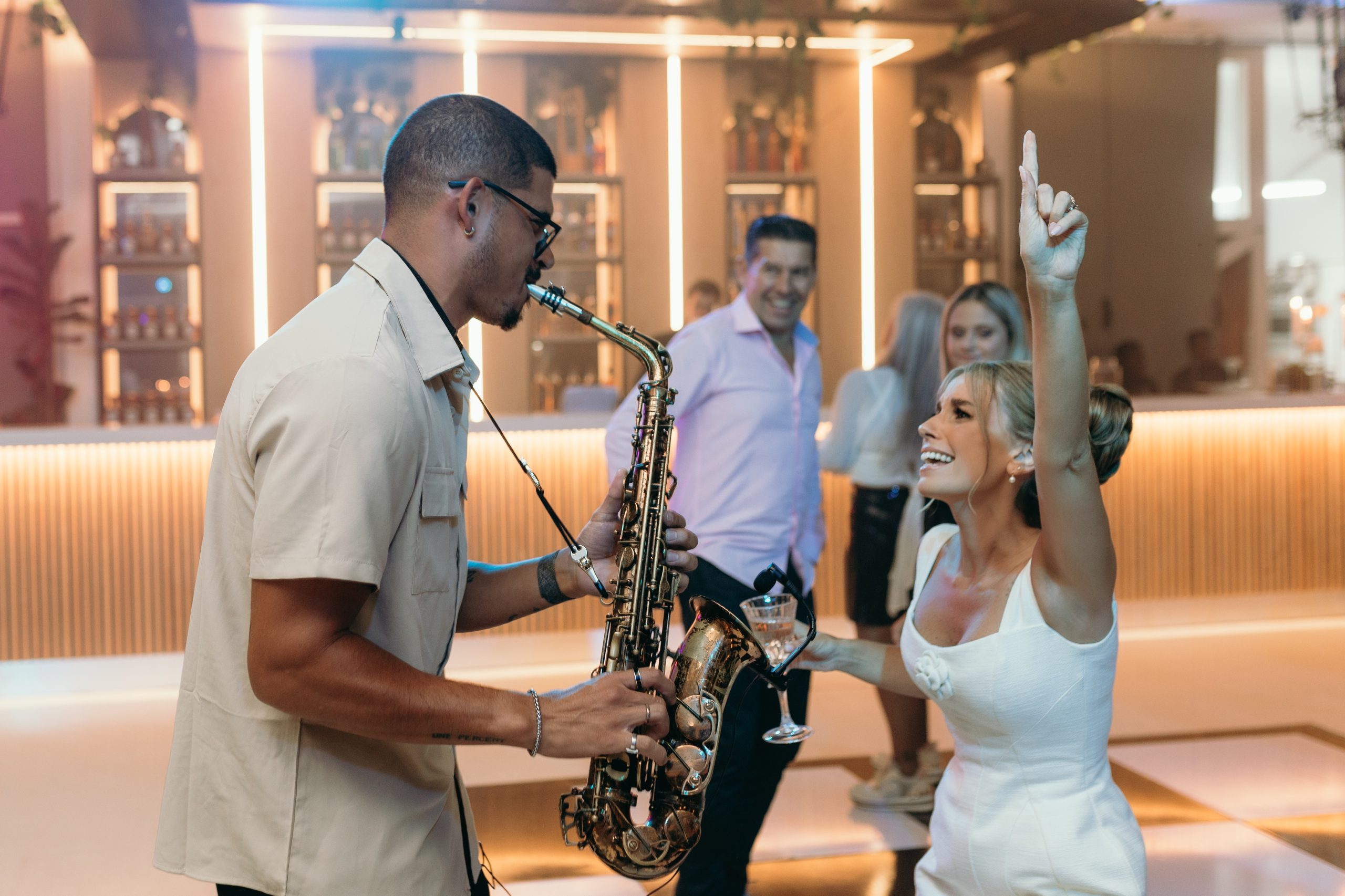 DJ PLUS saxophonist performing at a celebration